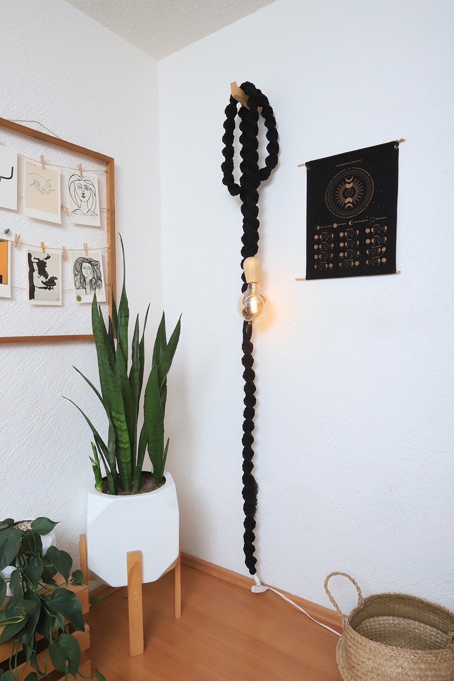 Lampara luciérnaga negra colgada en una habitación de pared blanca